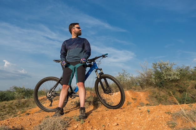 Berggipfel erobern mit Radler in Shorts und Jersey auf einem modernen Carbon-Hardtail-Bike