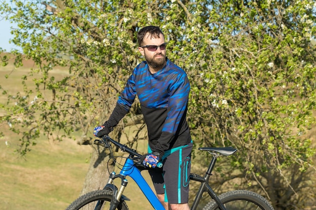 Berggipfel erobern per Radler in Shorts und Trikot auf einem modernen Carbon-Hardtail-Bike