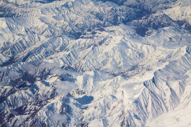 Berggipfel im Schnee aus einem Flugzeugfenster