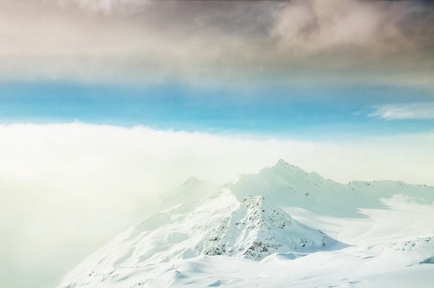 Berggipfel und Wolken bei Sonnenuntergang. Schöne Winterlandschaft