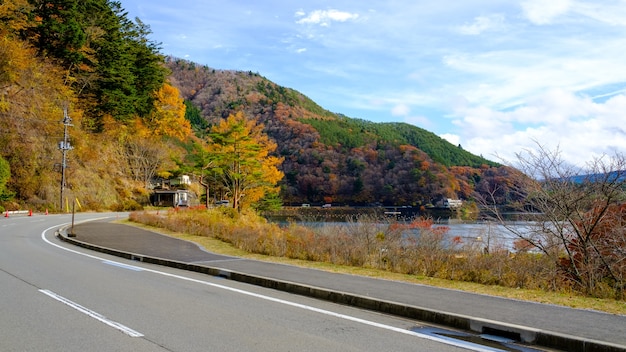 Bergherbstsaison auf geschwungenem Weg und Lagune in Japan