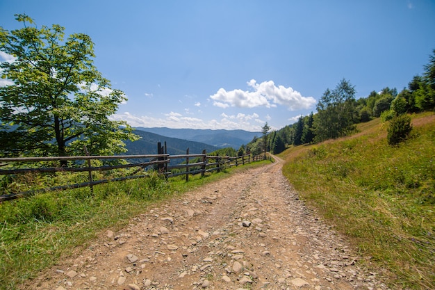 Berghügel reine Natur ländliche Landschaft. Zaun aus Holzstämmen.