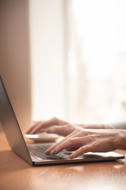 Übergibt Laptop mit hellem Sonnenlicht aus dem Fenster