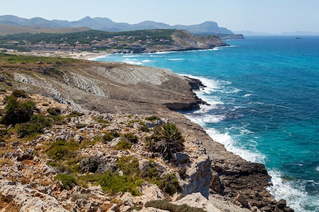 Bergküste Mittelmeerküste mit wilder Vegetation und tosenden Wellen