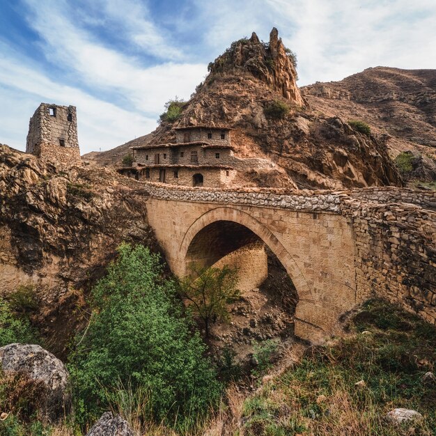 Berglandschaft mit alter Steinbrücke. Kinodorf, quadratisches Panorama. Dagestan.