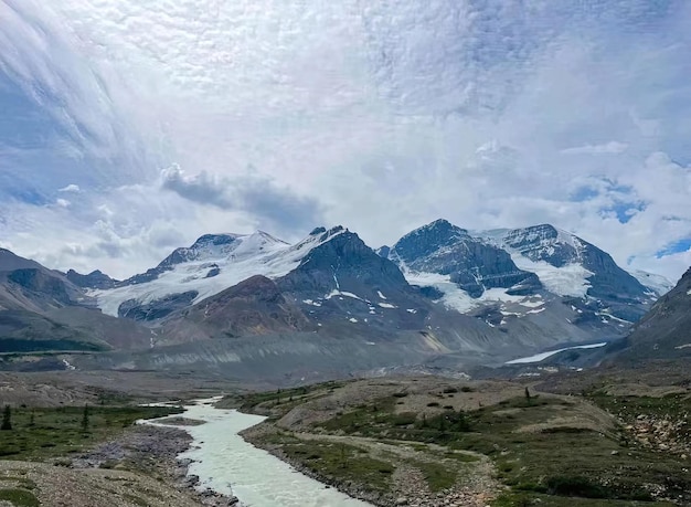 Foto berglandschaft mit einem fluss im vordergrund und einem gletscher im hintergrund