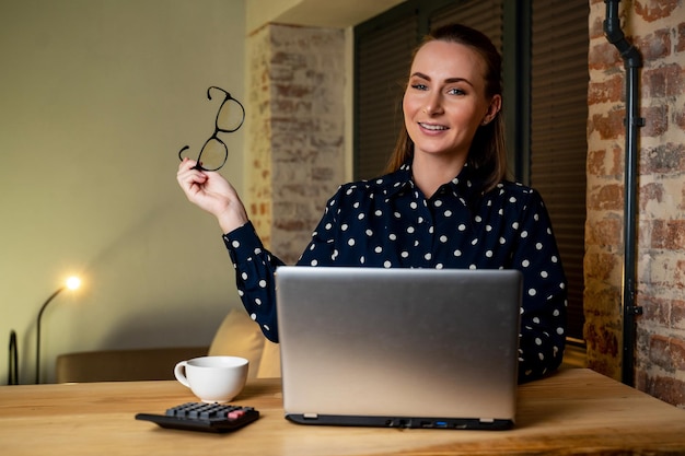 Überglücklich schaut eine glückliche Frau mit Brille auf einen Laptop-Bildschirm liest eine E-Mail mit erstaunlichen Neuigkeiten feiert den Gewinn einer Online-Lotterie erhält die Genehmigung eines Bankdarlehens