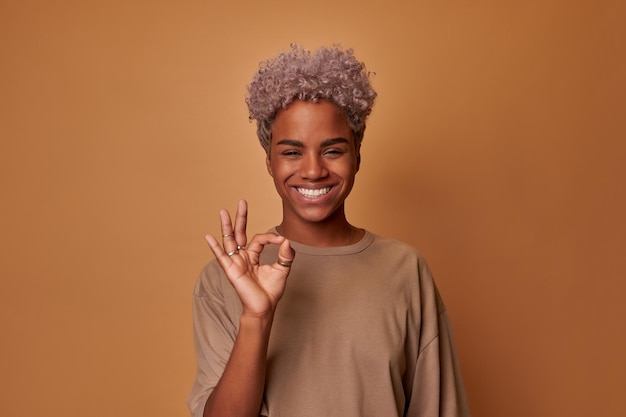 Überglückliche junge Afroamerikanerin zeigt Zustimmung OK Geste