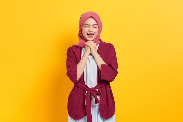 Überglückliche schöne asiatische Frau im legeren Hemd, die glücklich lächelt und selbstbewusst aussieht, isoliert vor gelbem Hintergrund
