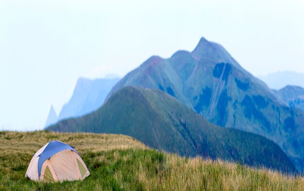 Bergpanorama mit touristischem Zelt. Sonnenaufgang oder Sonnenuntergang in den Bergen. Wanderkonzept.
