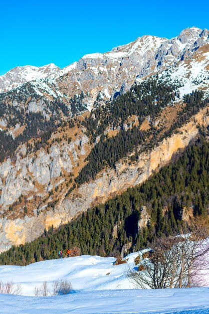 Bergpanorama mit zwei Bergsteigern in der Ferne im Schnee