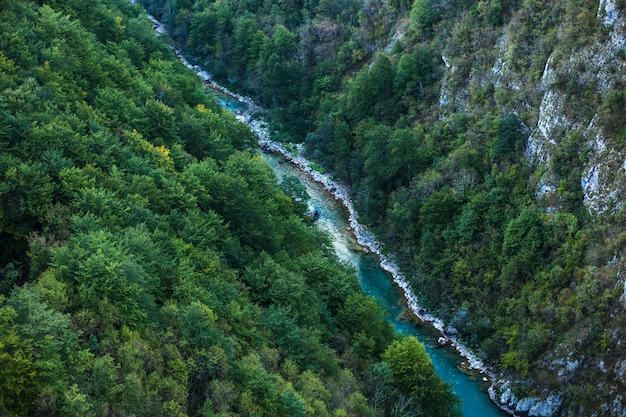 Bergschlucht mit einem Fluss darunter. Grüne Berge. Schlucht des Gebirgsflusses an steilen Hängen