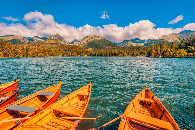 Bergsee mit Nadelwäldern Holzboot sonnig blauer Himmel idyllische Freiheit Reise Hintergrund