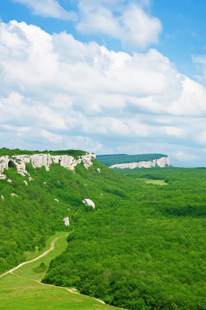 Bergsommerlandschaft mit Wolken und grünen Hügeln