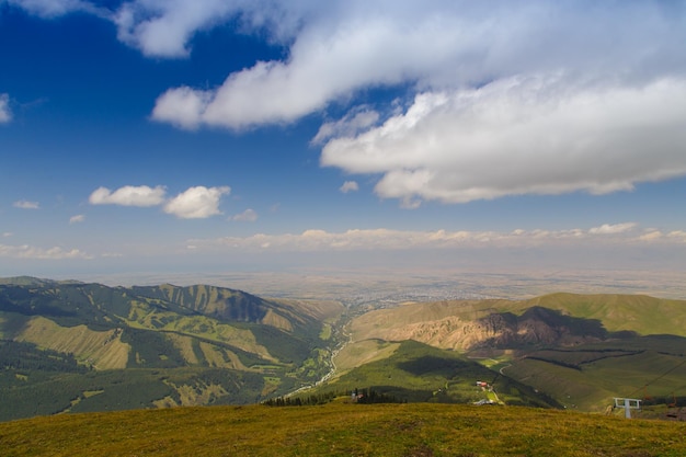 Bergsommerlandschaft Schneebedeckte Berge und grünes Gras Peak Karakol Kirgisistan Schöne Aussicht von der Spitze des Berges