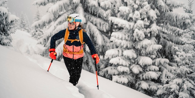 Foto bergsteiger backcountry ski wandern ski frau alpinist in den bergen skitouren in alpiner landschaft mit schneebedeckten bäumen abenteuer wintersport freeride-skifahren