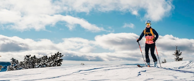 Bergsteiger Backcountry Ski Wandern Ski Frau Alpinist in den Bergen Skitouren in alpiner Landschaft mit schneebedeckten Bäumen Abenteuer Wintersport Freeride-Skifahren