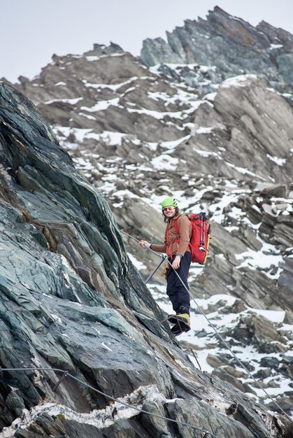 Bergsteiger, der felsigen Berg in Österreich klettert