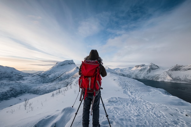 Bergsteiger mit Rucksack auf Berggipfel im Winter