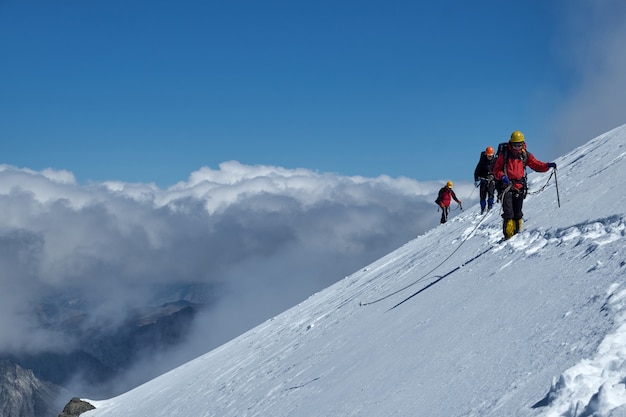 Bergsteiger oder Alpinisten erklimmen den Gipfel eines schneebedeckten Berges