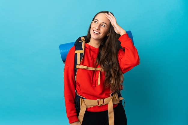 Bergsteigerfrau mit einem großen Rucksack über isoliertem Hintergrund, die viel lächelt