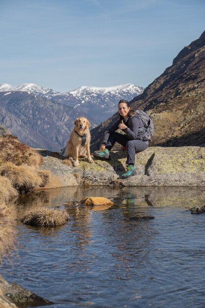 Bergsteigermädchen mit ihrem Golden Retriever-Hund auf dem Berg am See