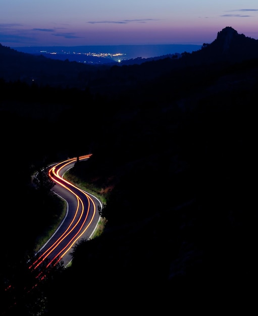 Bergstraße in der Nacht mit Autos, die sich schnell bewegt, Farbtonbild