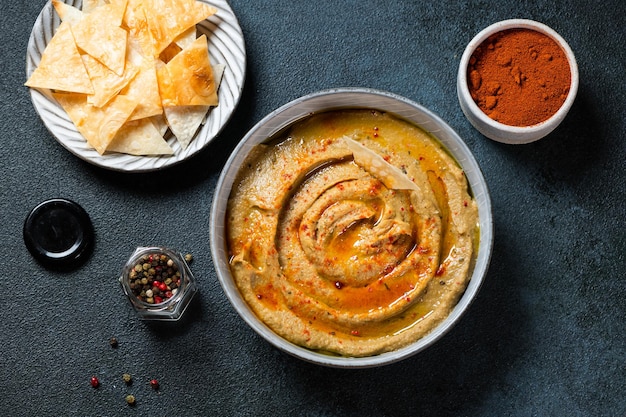 Berinjela árabe tradicional mergulho baba ganoush com ervas e páprica defumada em fundo escuro. Húmus de berinjela. Babaganush ou caviar de berinjela. Berinjela assada. Molho turco de berinjela