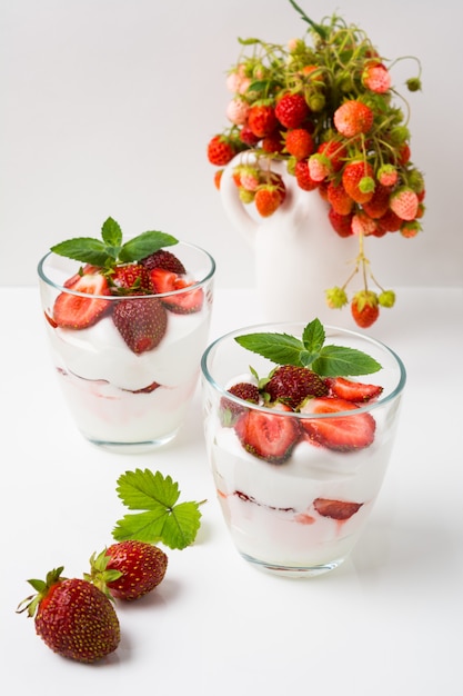 Überlagerter Erdbeerfrischkäsenachtisch auf weißem Hintergrund