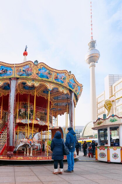 Berlim, alemanha - 10 de dezembro de 2017: carrossel com crianças no mercado de natal na alemanha na europa no inverno. feira de férias de natal de rua alemã em berlim na alexanderplatz