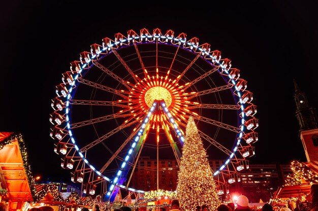 Berlim, Alemanha - 10 de dezembro de 2017: Roda gigante e árvore de Natal no mercado de Natal à noite na Câmara Municipal em Berlim de inverno, Alemanha.