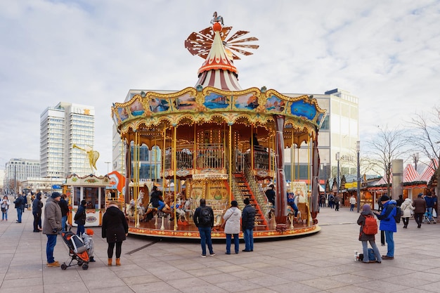 Berlín, Alemania - 10 de diciembre de 2017: Carrusel en el mercado navideño en Alexanderplatz en Winter Berlin, Alemania. Feria de Adviento Decoración y Puestos con Artículos de Artesanía en el Bazar.