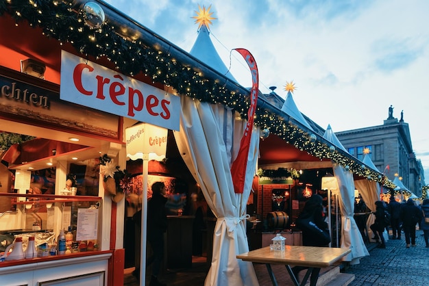 Berlin, Deutschland - 8. Dezember 2017: Crêpes-Pfannkuchen auf dem Nachtweihnachtsmarkt am Gendarmenmarkt im Winter Berlin, Deutschland. Adventmarkt Dekoration und Stände mit Kunsthandwerk auf dem Basar.