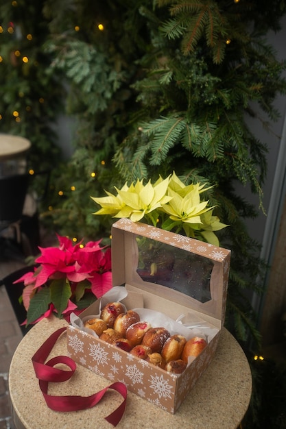 Berliner de donuts alemão com recheio e açúcar de confeiteiro em uma caixa em uma mesa de pedra marrom Sobre fundo de decoração de Natal