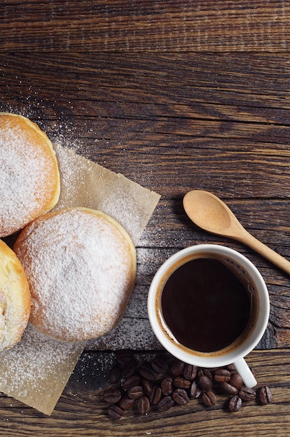 Foto berliner donuts und kaffee zum frühstück auf dunklem holztisch