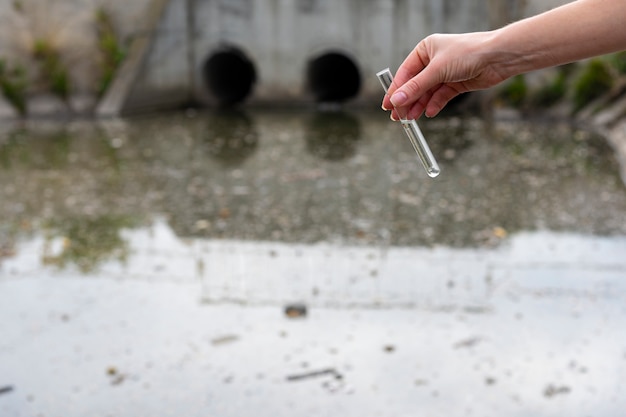 Überprüfung der Wasserqualität im Abwasser. Reagenzglas mit einer Probe in der Hand. Abwasserbehandlung