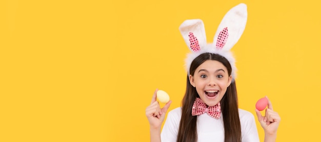Überrascht Ostern Kind Mädchen in Hasenohren und Fliege halten bemalte Eier Ostern Kind horizontale Poster Web-Banner-Header von Bunny Kid Copy Space
