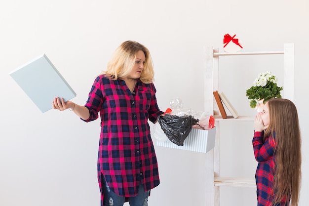 Überraschte Frau hält Box mit Plastikmüll