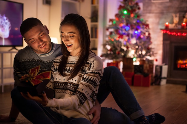 Überraschte Freundin der magischen Geschenkbox vom Freund am Weihnachtstag.