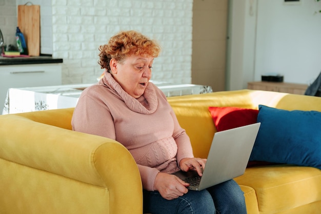 Überraschte kaukasische dicke Frau, die online auf dem Laptop schaut und eine schlechte Nachricht mit Internetverbindung sieht ...