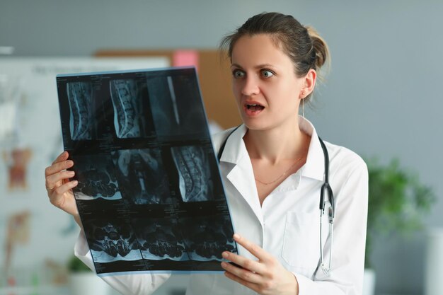 Überraschte professionelle Ärztin mit Patientenergebnis auf Röntgenaufnahme