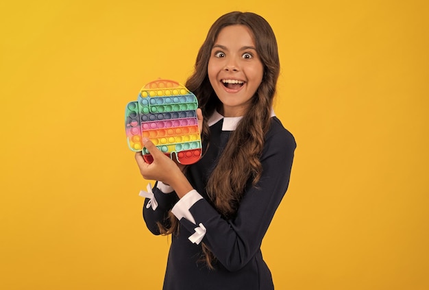 Überraschtes jugendlich Mädchen, das Popit-Silikon-sensorisches Fidget-Spielzeug Anti-Stress-Spielzeug präsentiert