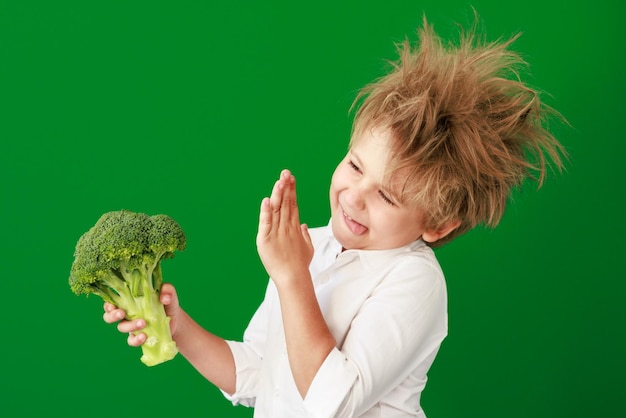 Überraschtes Kind gegen grüne Tafel im Unterricht