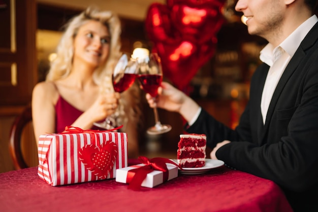 Überraschung für den Valentinstag Junges Paar feiert den Valentinstag mit einem Glas Rotwein