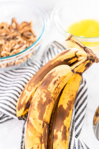 Überreife Bananen schälen und zerdrücken, um Bananen-Nuss-Brot herzustellen.