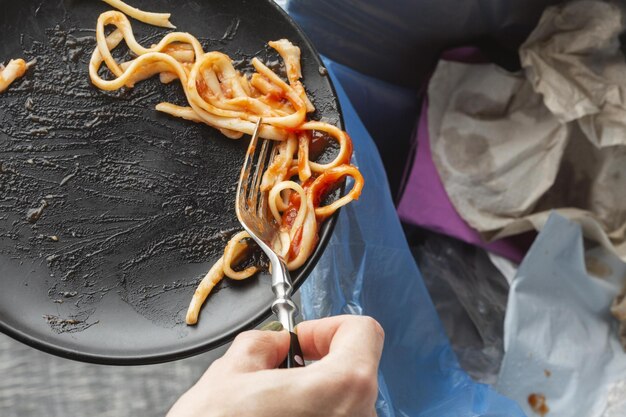 Überreste verschwendeter Spaghetti-Pasta in den Mülleimer geworfen hochwertige schöne Foto-Konzept