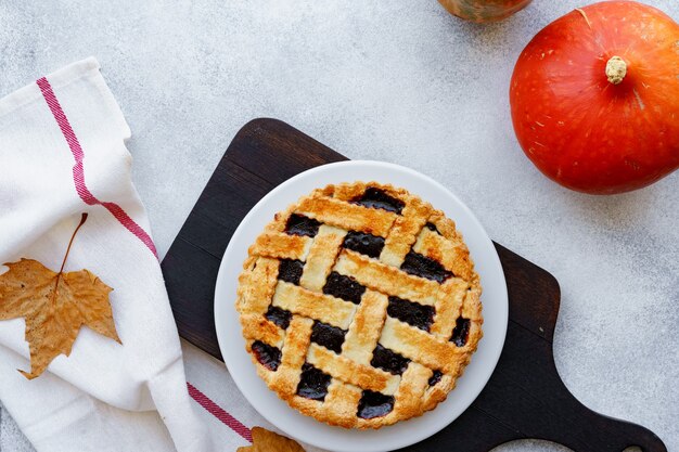 Berry Tart Pie und Orangenkürbis auf Holztisch