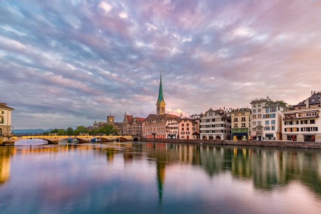 Berühmte Fraumünster-Kirche mit ihren Spiegelungen im Fluss Limmat bei Sonnenaufgang in der Altstadt von Zürich, der größten Stadt der Schweiz