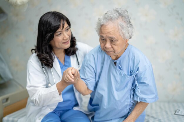 Foto berührende asiatische senioren oder ältere alte dame patientin mit liebevoller pflege hilft, zu ermutigen und mitgefühl auf der krankenhausstation zu fördern gesundes starkes medizinisches konzept