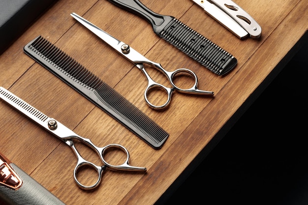 Berufliche Friseurwerkzeuge, die auf einer Holzoberfläche für die Friseursitzung für Männer ausgelegt sind